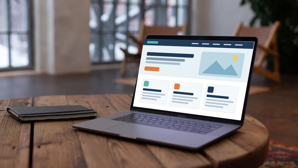 Laptop on a wooden table showing a generic business website mock-up