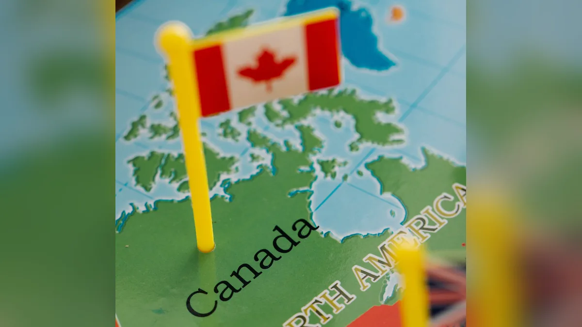 Canadian flag pinned on a map of North America